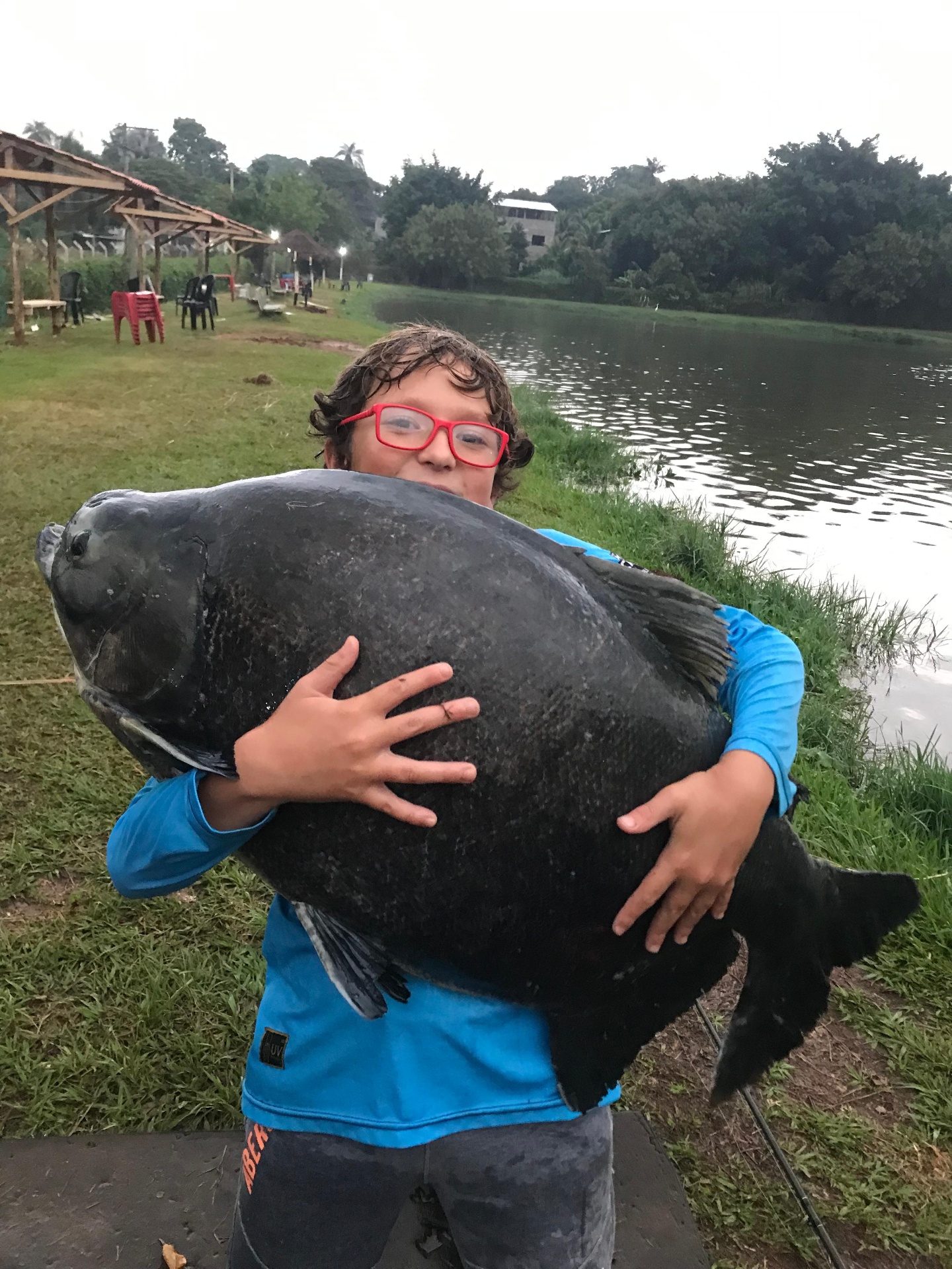 Criança segurando tambaqui gigante