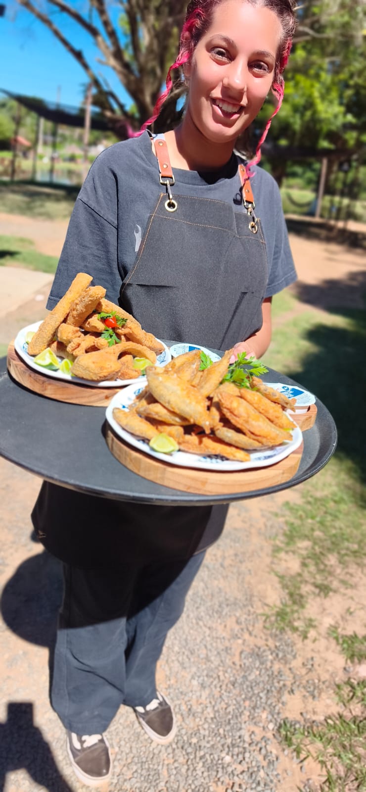 Atendente servindo pratos de peixe frito